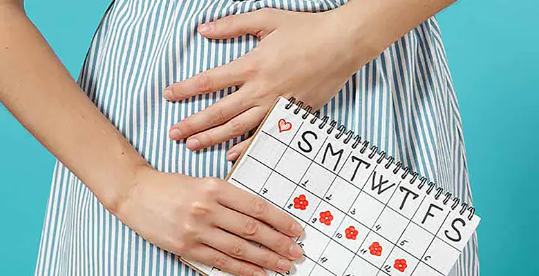 women holding a calendar and a hand in her belly